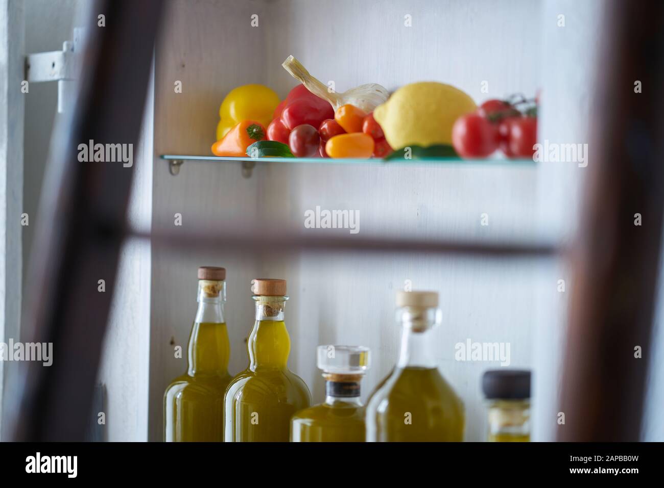 still life closeup vegetable in kitchen shelf detail bottles olive oil kitchen rural rustic country,glass deco gold food cooking natural nice organic Stock Photo