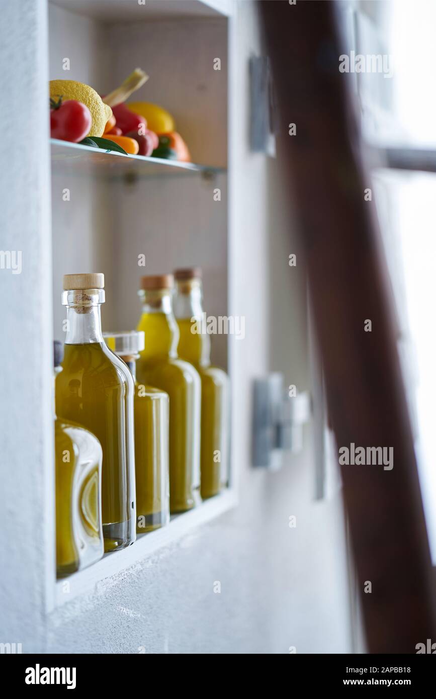atmospheric still life detail closeup from a shelf in store shop retail sell  wall in country rural style,bottles oil vegetable lemon tomatoes,blurred Stock Photo