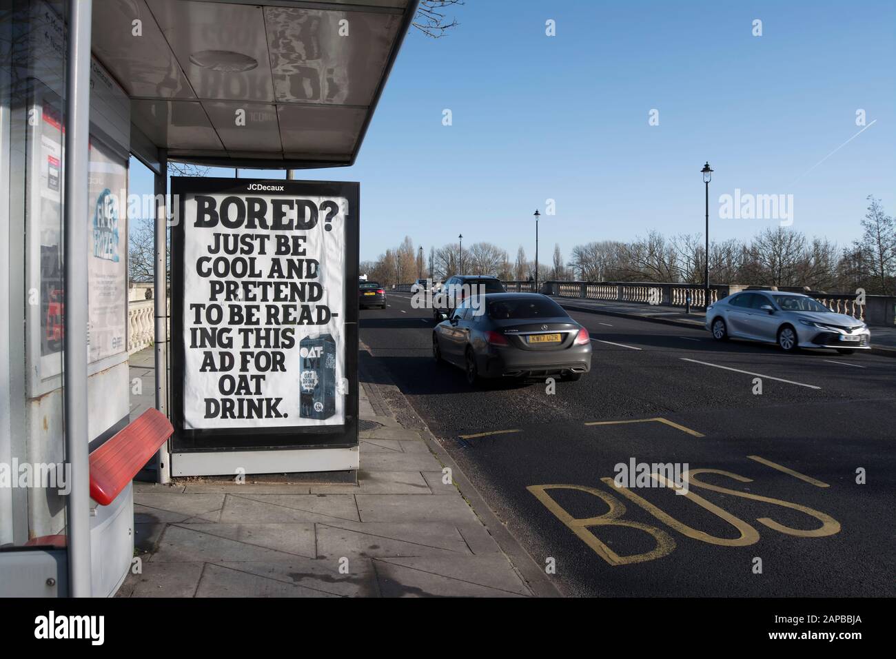 bus stop on chiswick bridge, london, england, with large advertisement for oatly drinks with text asking bored? Stock Photo