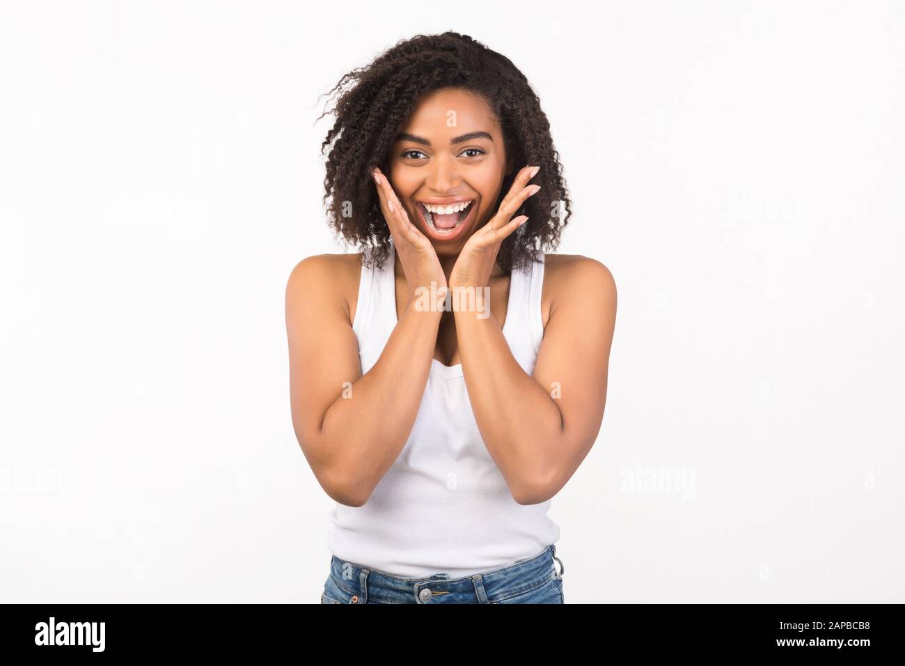 Happy black woman screaming and holding cheeks Stock Photo