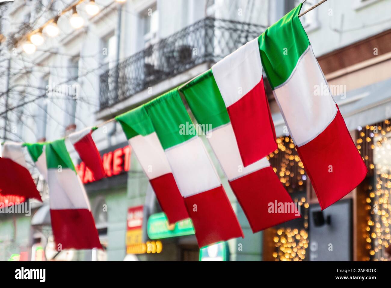 Flag of Italy hang on a city street. Tri-color flag fabric Stock Photo