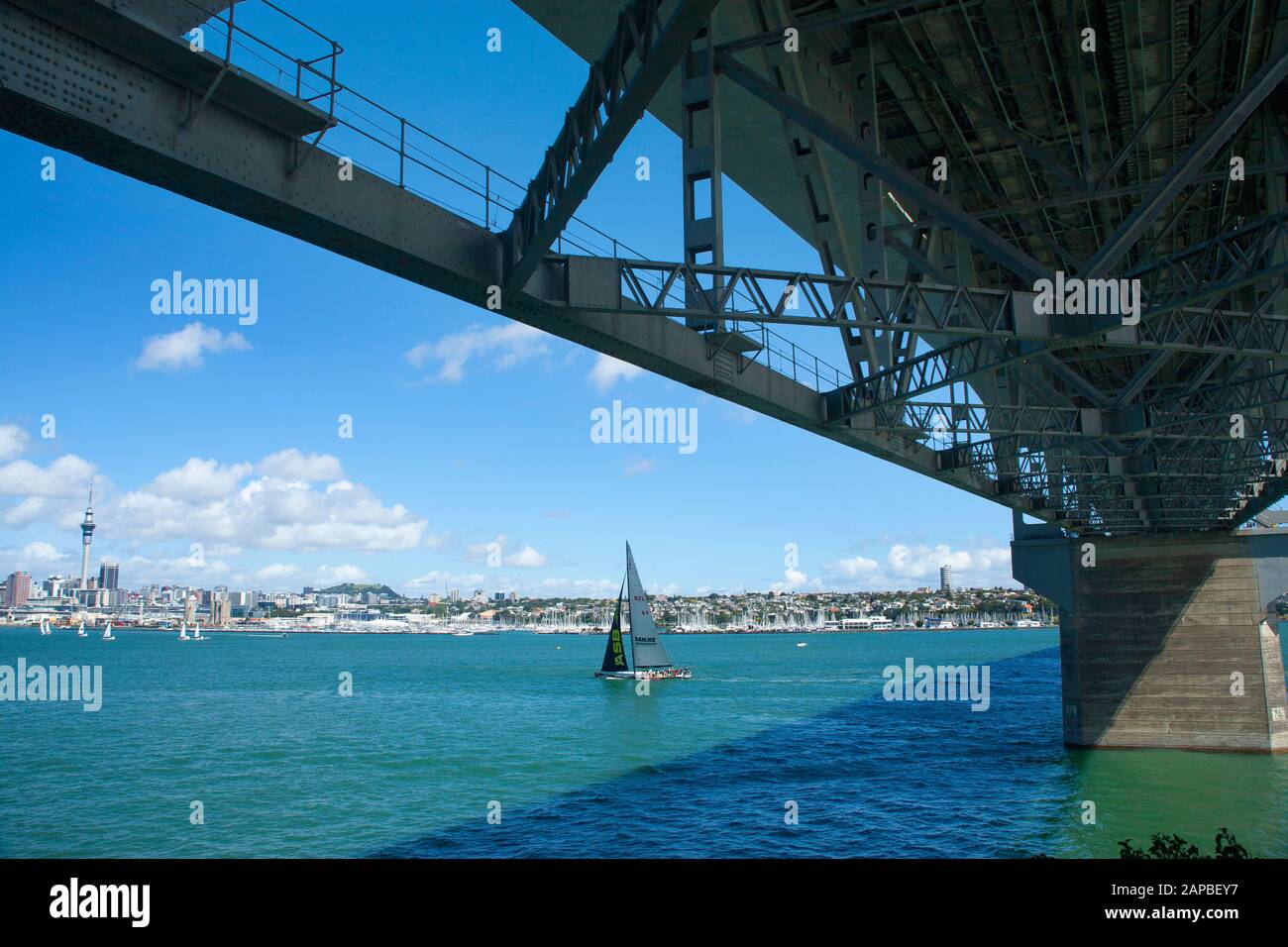 Looking over Waitemata Harbour at downtown Auckland city from the North Shore with the underside of the Harbour Bridge in foreground. New Zealand. Stock Photo