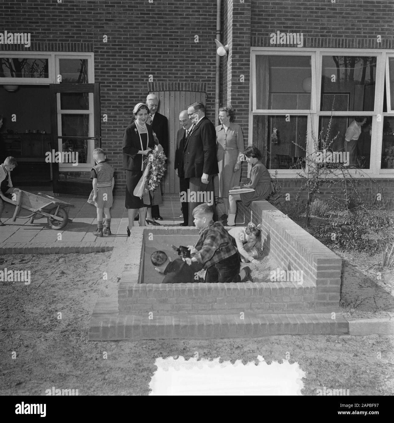 Visit of the Danish royal family, third day, visit to the Blind Institute in Huizen. Queen Ingrid at children in the sandbox Date: 28 April 1954 Location: Homes, Noord-Holland Keywords: blind, queens, state visits Personal name: Ingrid (queen Denmark) Stock Photo