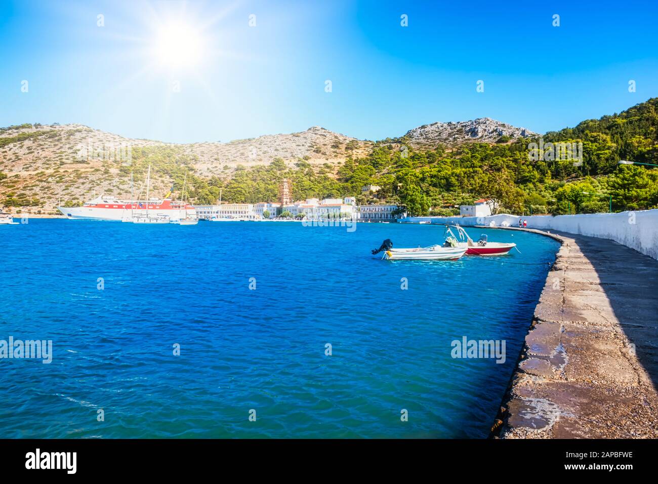 View of bay with boats and Monastery of Taxiarchis Mihail Panormitis on Island of Symi  (Rhodes, Greece) Stock Photo