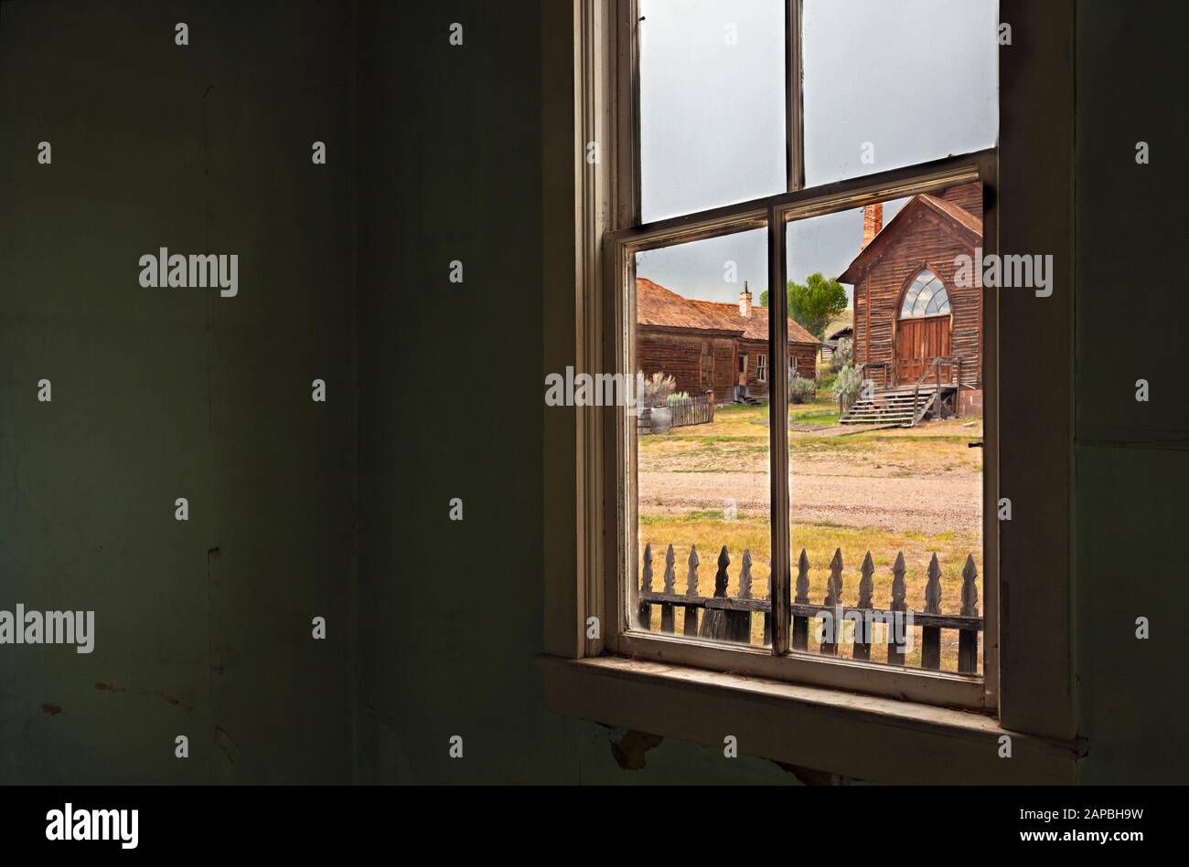 MT00435-00...MONTANA - View out of the window of a settlers cabin across Main Street to the only church in the ghost town of Bannack in Bannack State Stock Photo