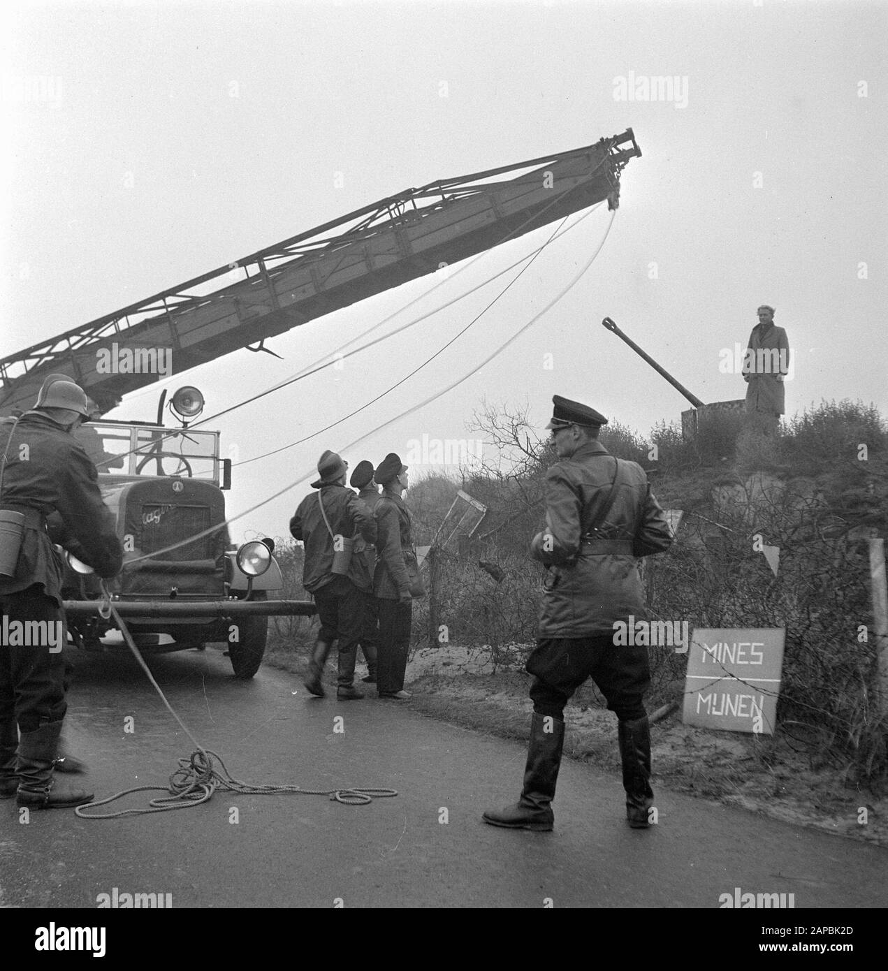 The Hague police and fire department rescue a boy from a former German bunker in a minefield. He was rescued with the help of the Magirus car ladder of the Hague Fire Department Date: 24 December 1945 Location: The Hague, Zuid-Holland Keywords: fire brigade, explosives, children, police, rescue personname: Magirus Stock Photo