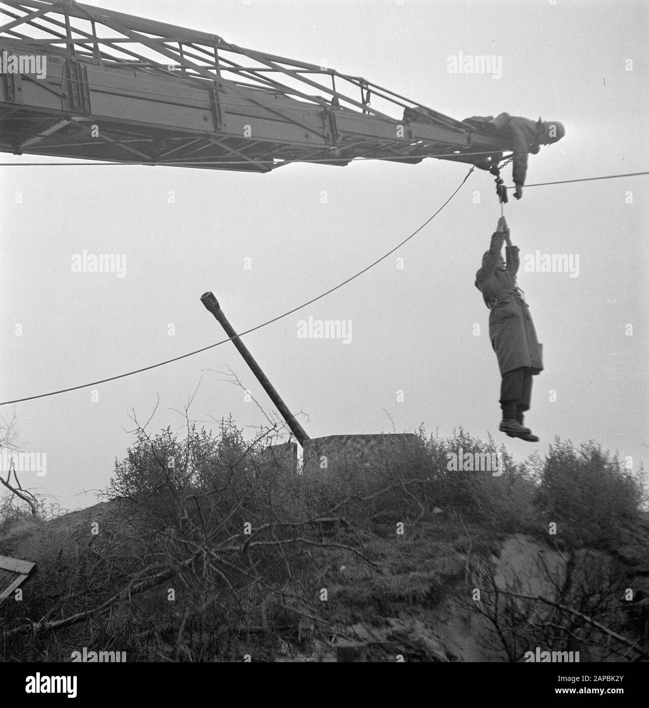 The Hague police and fire department rescue a boy from a former German bunker in a minefield. He was rescued with the help of the Magirus car ladder of the Hague Fire Department Date: 24 December 1945 Location: The Hague, Zuid-Holland Keywords: fire brigade, explosives, children, police, rescue personname: Magirus Stock Photo