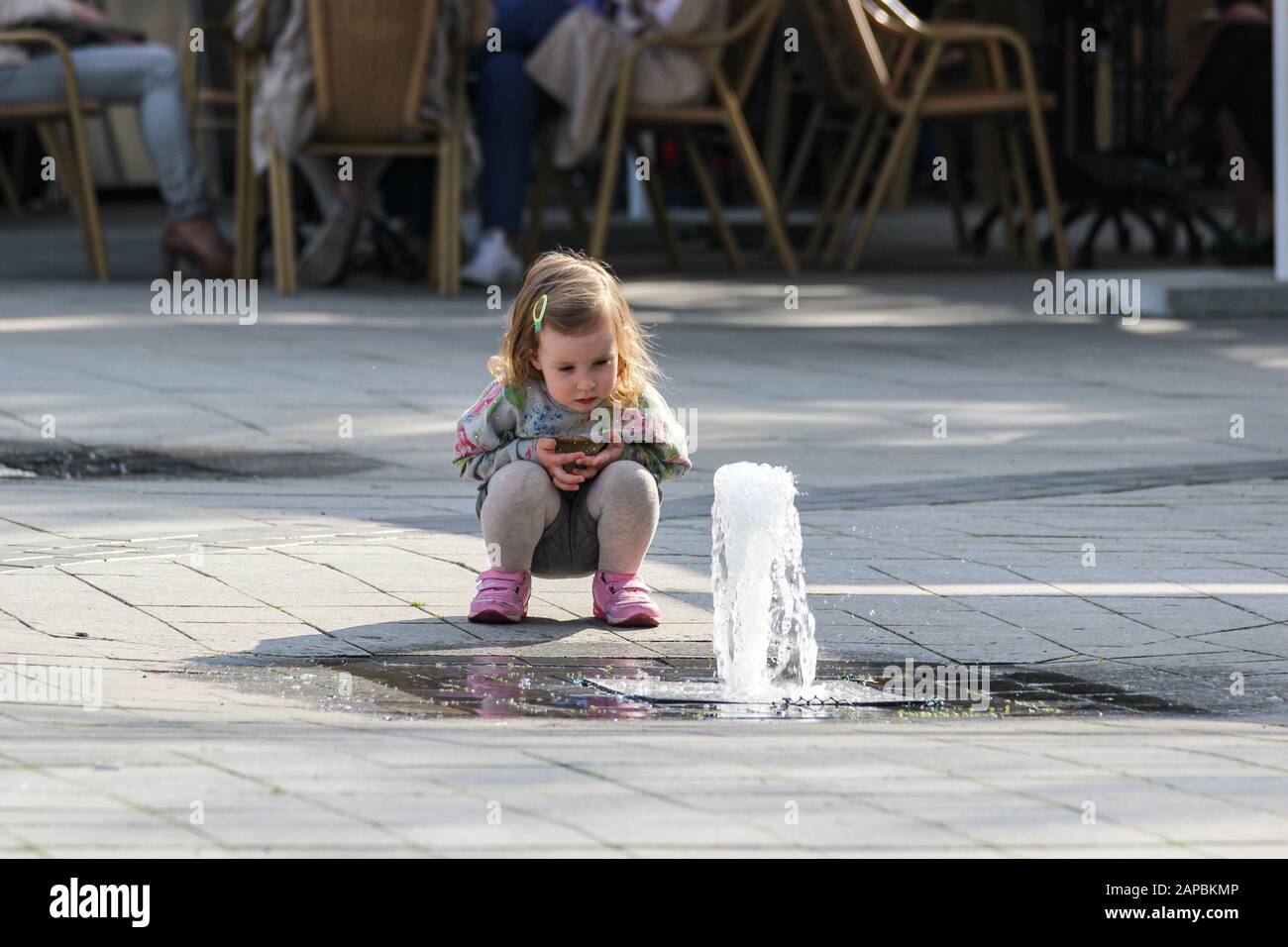 Little girl watching jet of water from the ground Stock Photo
