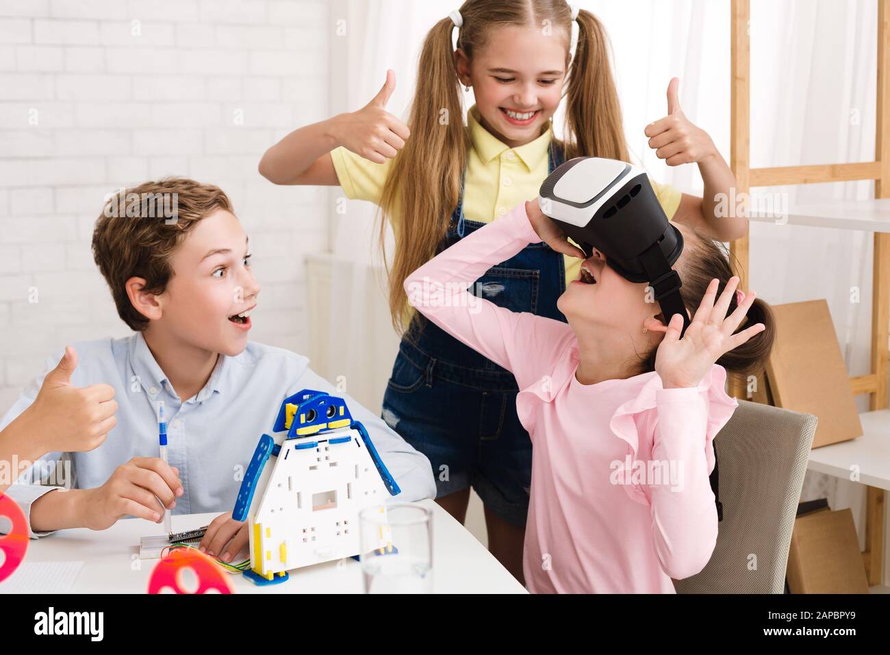 Excited girl using VR glasses at stem lesson Stock Photo