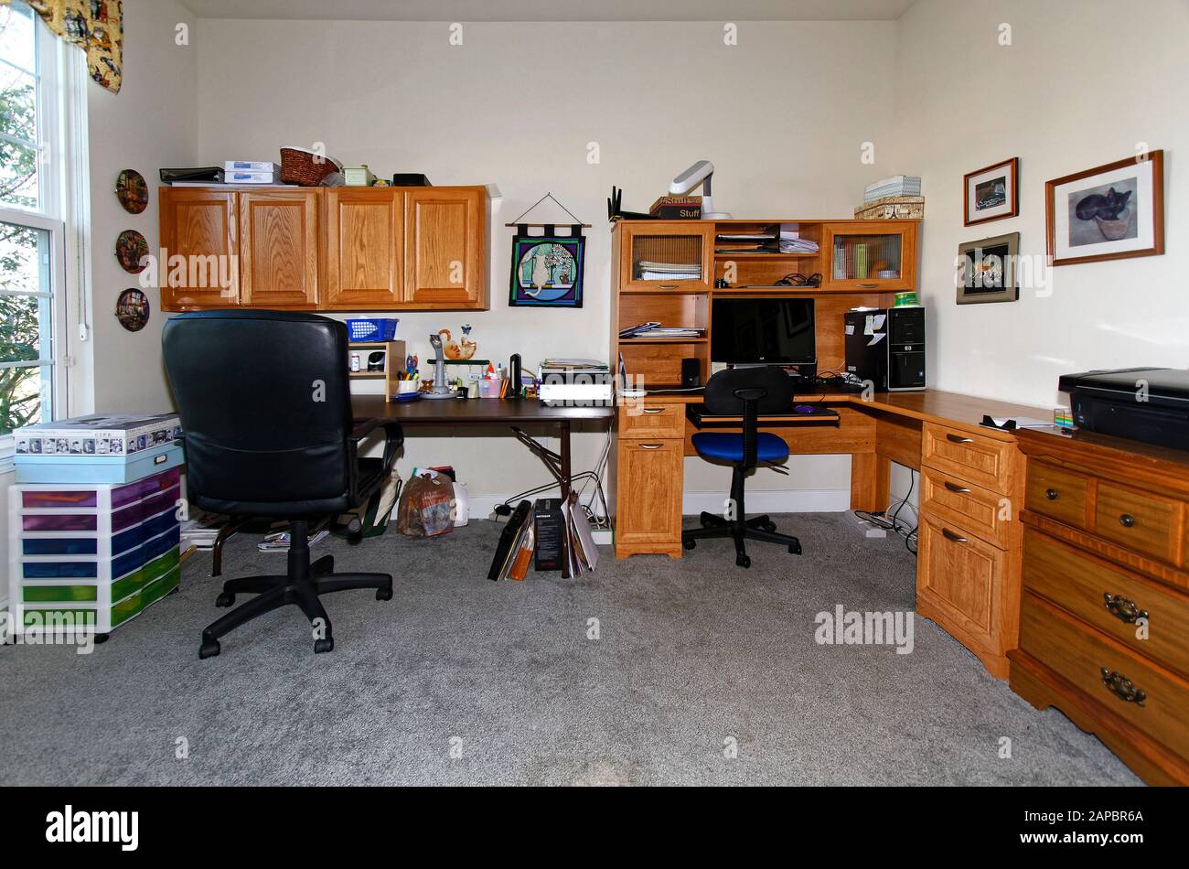 home office, L-shape desk, work table, wall cabinets, computer, chairs, lamps, craft equipment, window, horizontal; PR Stock Photo