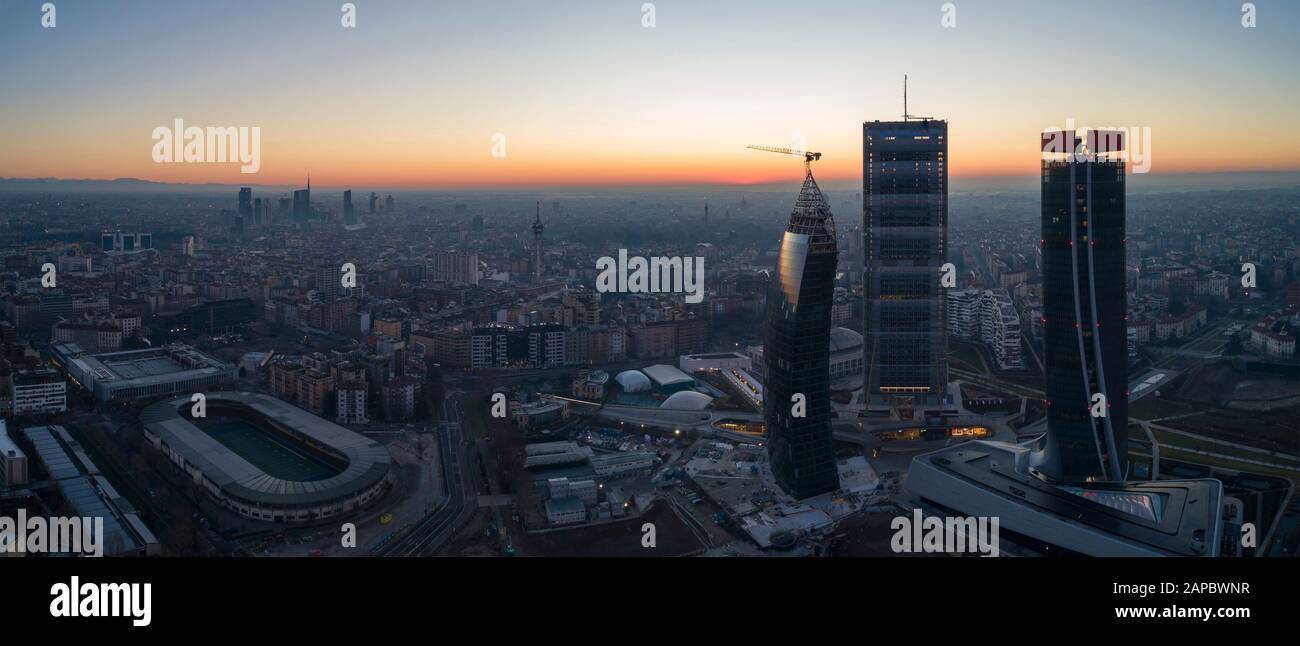Milan city skyline at sunrise, aerial view. The new 3 skyscrapers (called the straight, the curved and the crooked) of Citylife district at dawn. Stock Photo