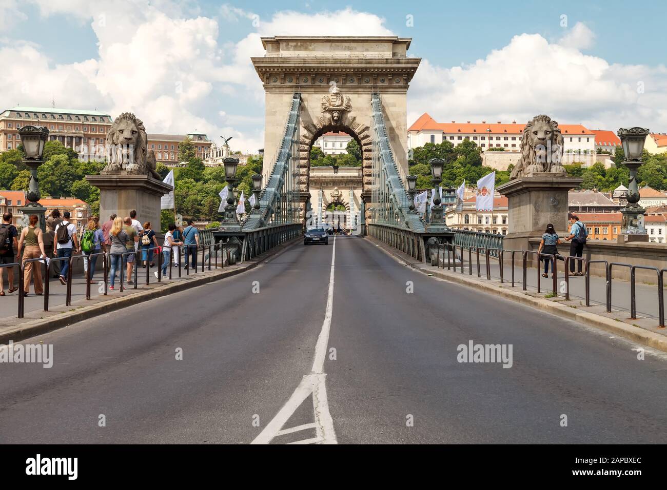 Cars cross the Secheni Chain Bridge in Budapest across the Danube River. Many tourists admire