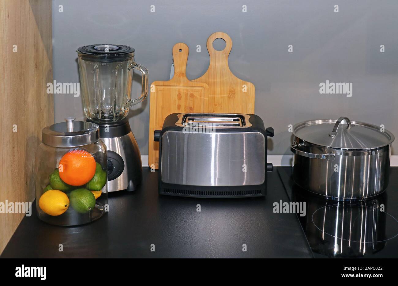 Toaster blender and pot on kitchen counter next to cooker panel in