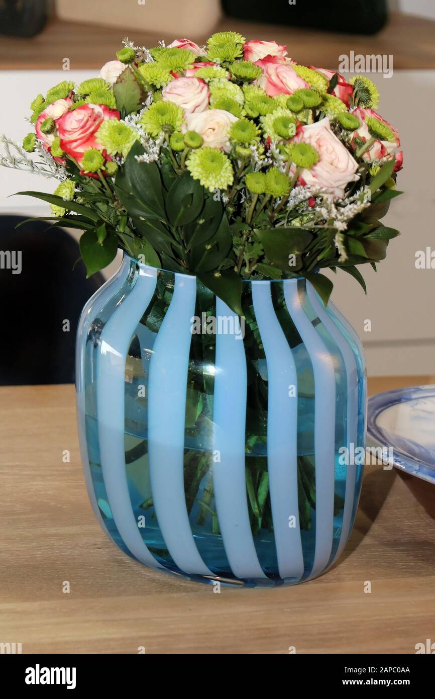 https://c8.alamy.com/comp/2APC0AA/small-roses-flower-in-blue-glass-vase-2APC0AA.jpg