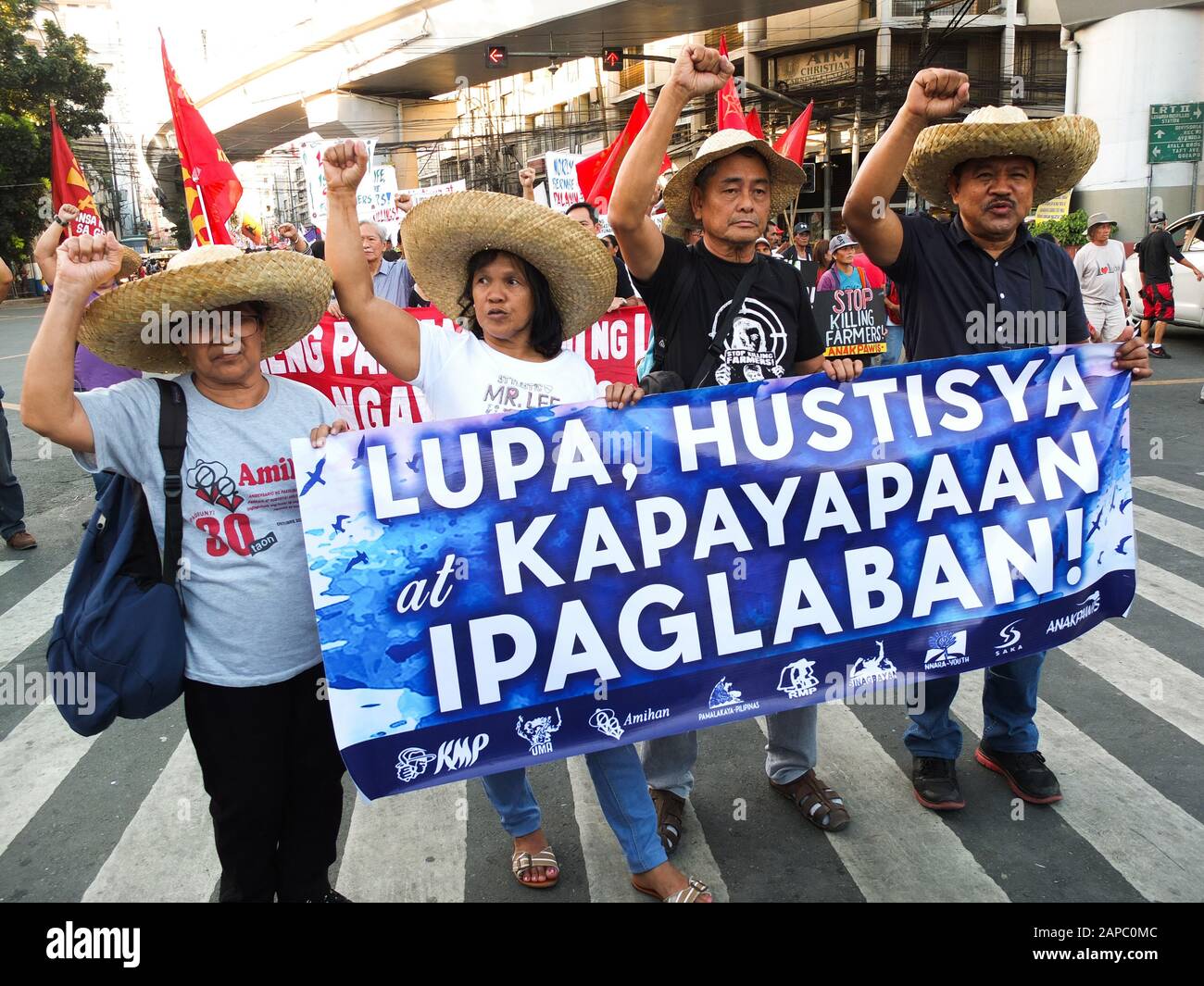 Manila, Philippines. 22nd Jan, 2020. Protesters wearing a native hat raise their fist while holding a banner during the demonstration.The Unyon ng mga Manggagawa sa Agrikultura called on the Filipino people to join the fight for genuine agrarian reform to deliver the ultimate justice for the victims of Mendiola Massacre, commemorating the 33rd year of the cold-blooded killing of the 13 farmers at the foot of Mendiola Bridge in Manila. Credit: SOPA Images Limited/Alamy Live News Stock Photo