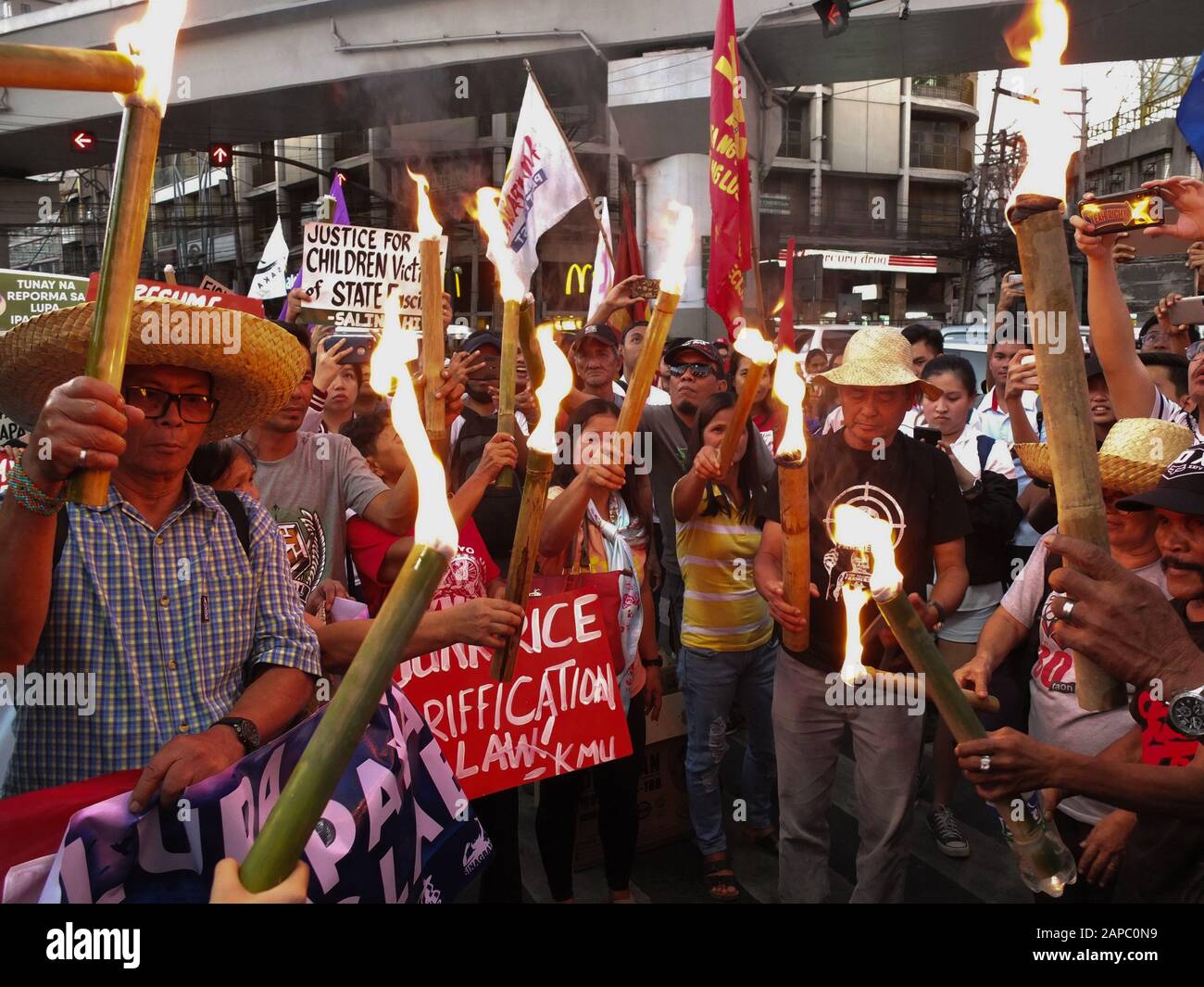 Manila, Philippines. 22nd Jan, 2020. Protesters hold lighting torches during the demonstration.The Unyon ng mga Manggagawa sa Agrikultura called on the Filipino people to join the fight for genuine agrarian reform to deliver the ultimate justice for the victims of Mendiola Massacre, commemorating the 33rd year of the cold-blooded killing of the 13 farmers at the foot of Mendiola Bridge in Manila. Credit: SOPA Images Limited/Alamy Live News Stock Photo