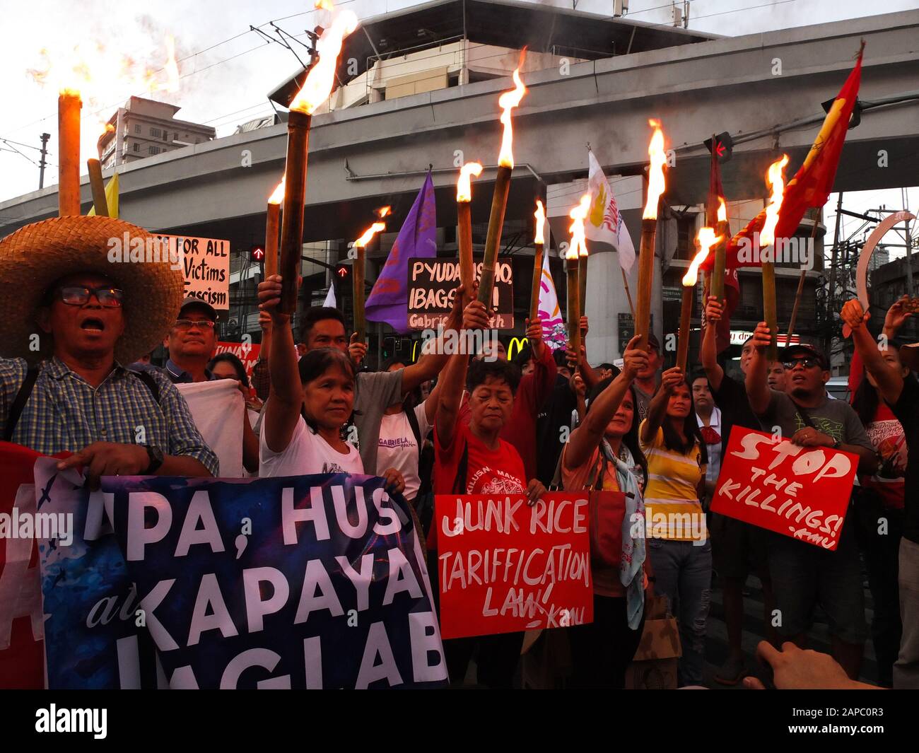 Manila, Philippines. 22nd Jan, 2020. Protesters hold lighting torches during the demonstration.The Unyon ng mga Manggagawa sa Agrikultura called on the Filipino people to join the fight for genuine agrarian reform to deliver the ultimate justice for the victims of Mendiola Massacre, commemorating the 33rd year of the cold-blooded killing of the 13 farmers at the foot of Mendiola Bridge in Manila. Credit: SOPA Images Limited/Alamy Live News Stock Photo
