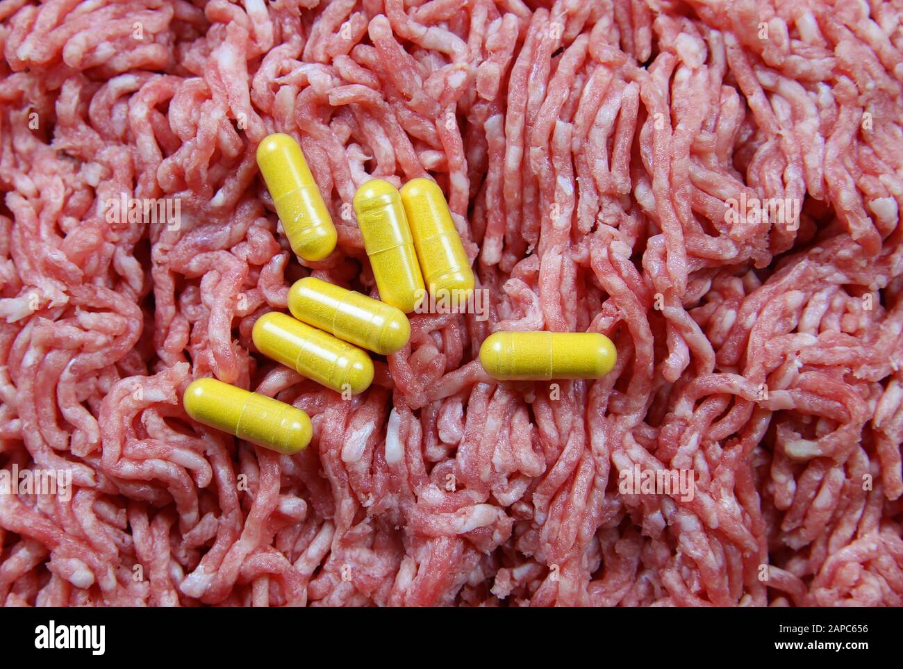 Antibiotic use in food producing animals concept: Yellow capsules with  minced raw meat background Stock Photo - Alamy