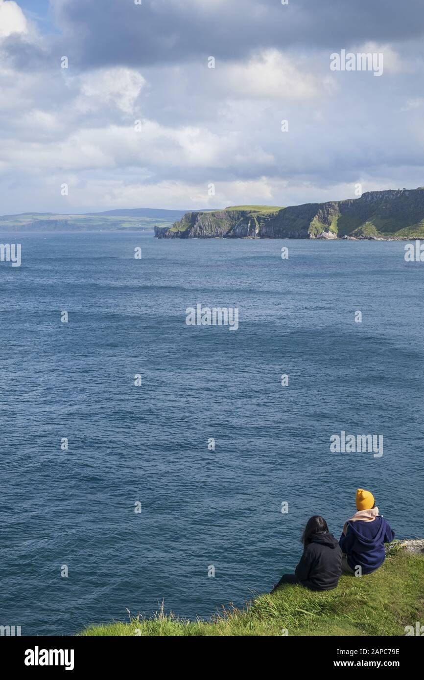 Hikers pausing for a rest at Torr Head on the Antrim coast causeway and coastal route Stock Photo