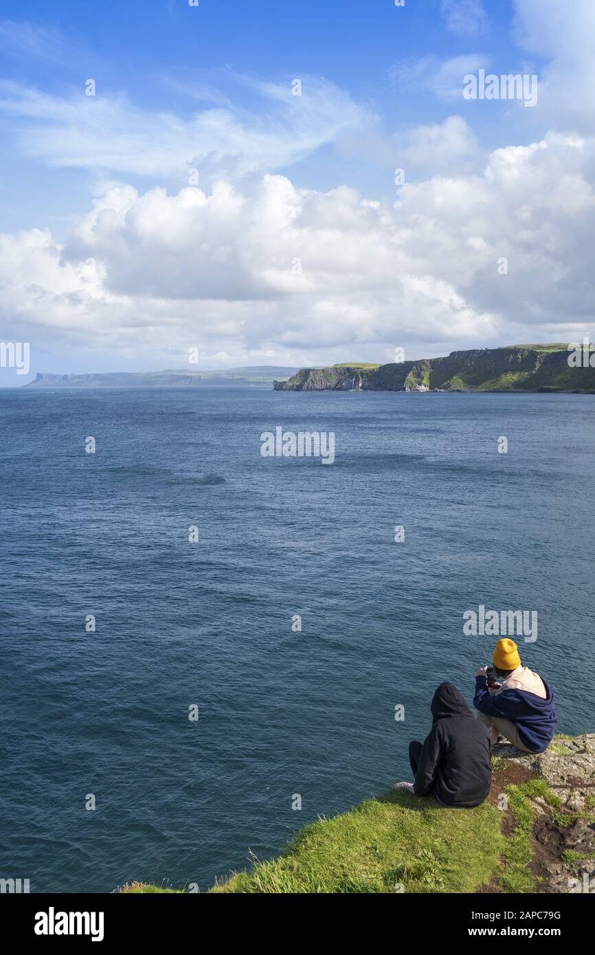 Hikers pausing for a rest at Torr Head on the Antrim coast causeway and coastal route Stock Photo