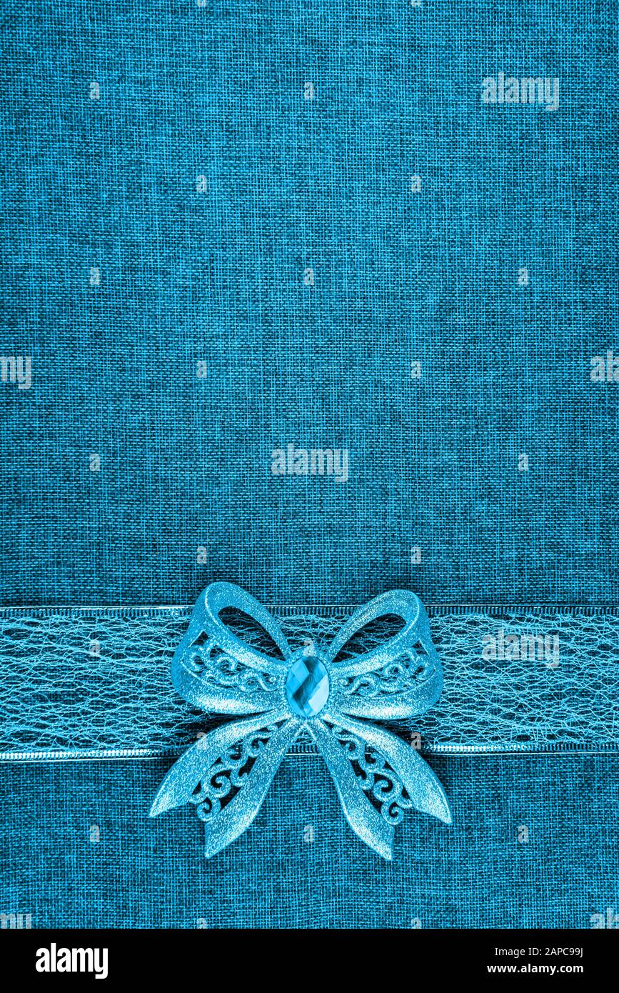 Elegant shiny blue glitter bow on blue colored ribbon and on blue burlap.  Vertical greeting card background with large copy space and decorated  bottom Stock Photo - Alamy