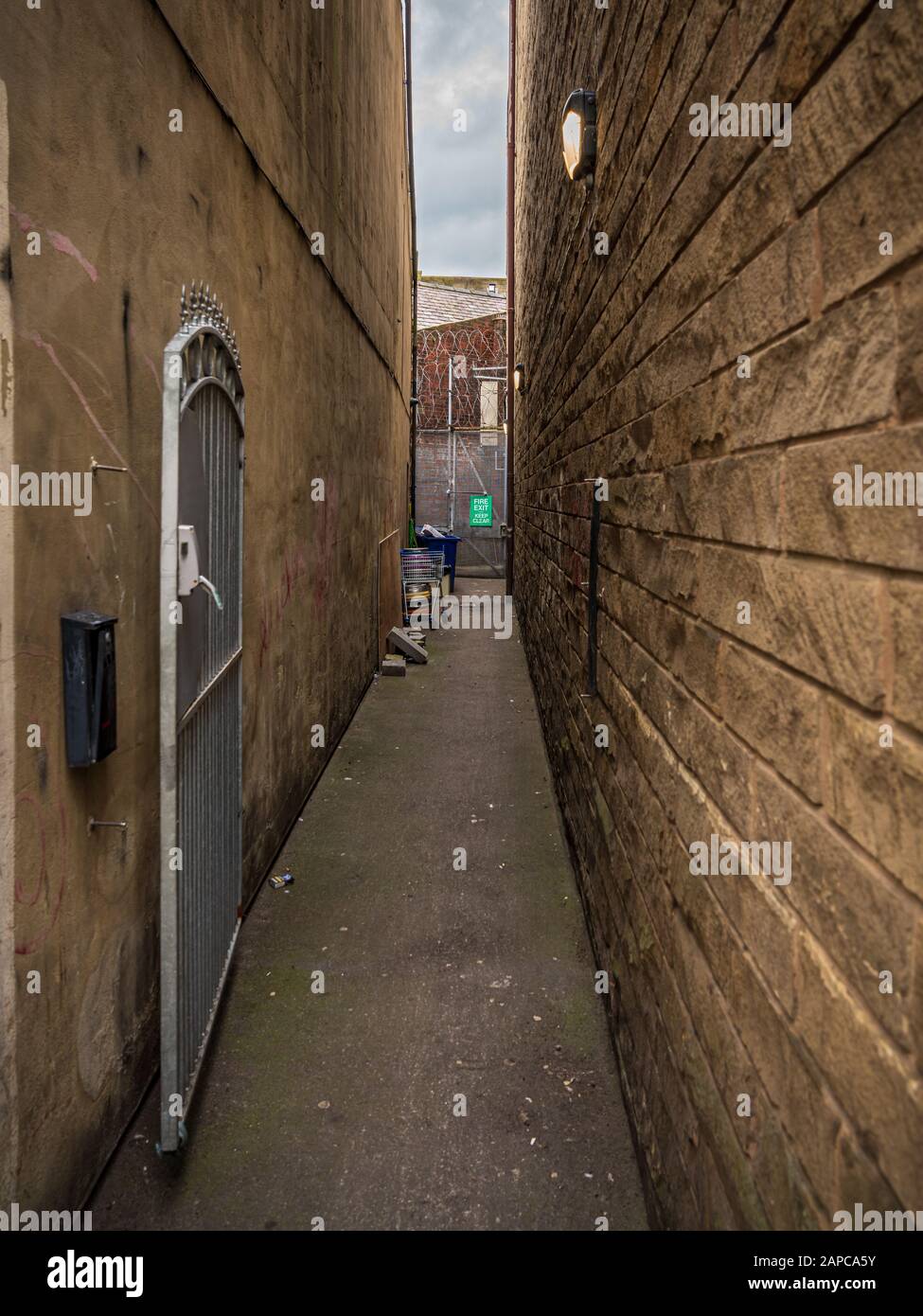 A small way between two houses leading to the Fire Exit, seen in Skipton, North Yorkshire, England, UK Stock Photo
