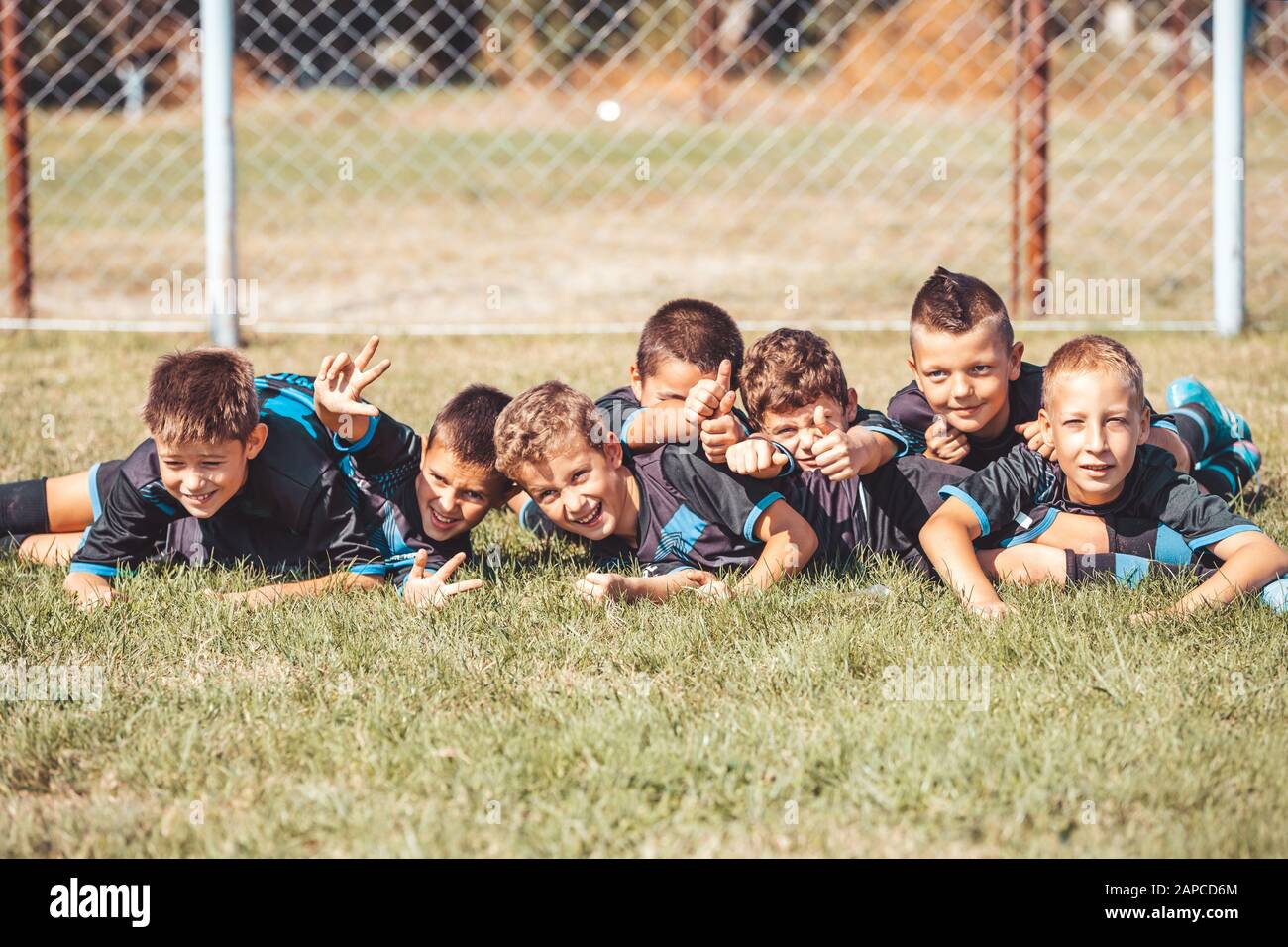Kids soccer football - young children players celebrating with their hands up, after victory. Stock Photo