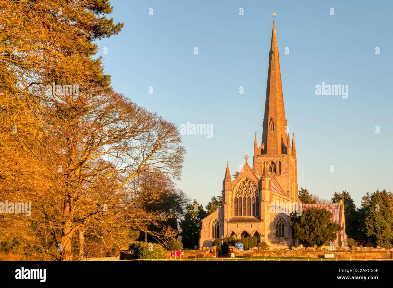 Evening sunlight catches the west front of St Mary's church in Snettisham. Pevsner called it 'perhaps the most exciting Decorated church in Norfolk'. Stock Photo