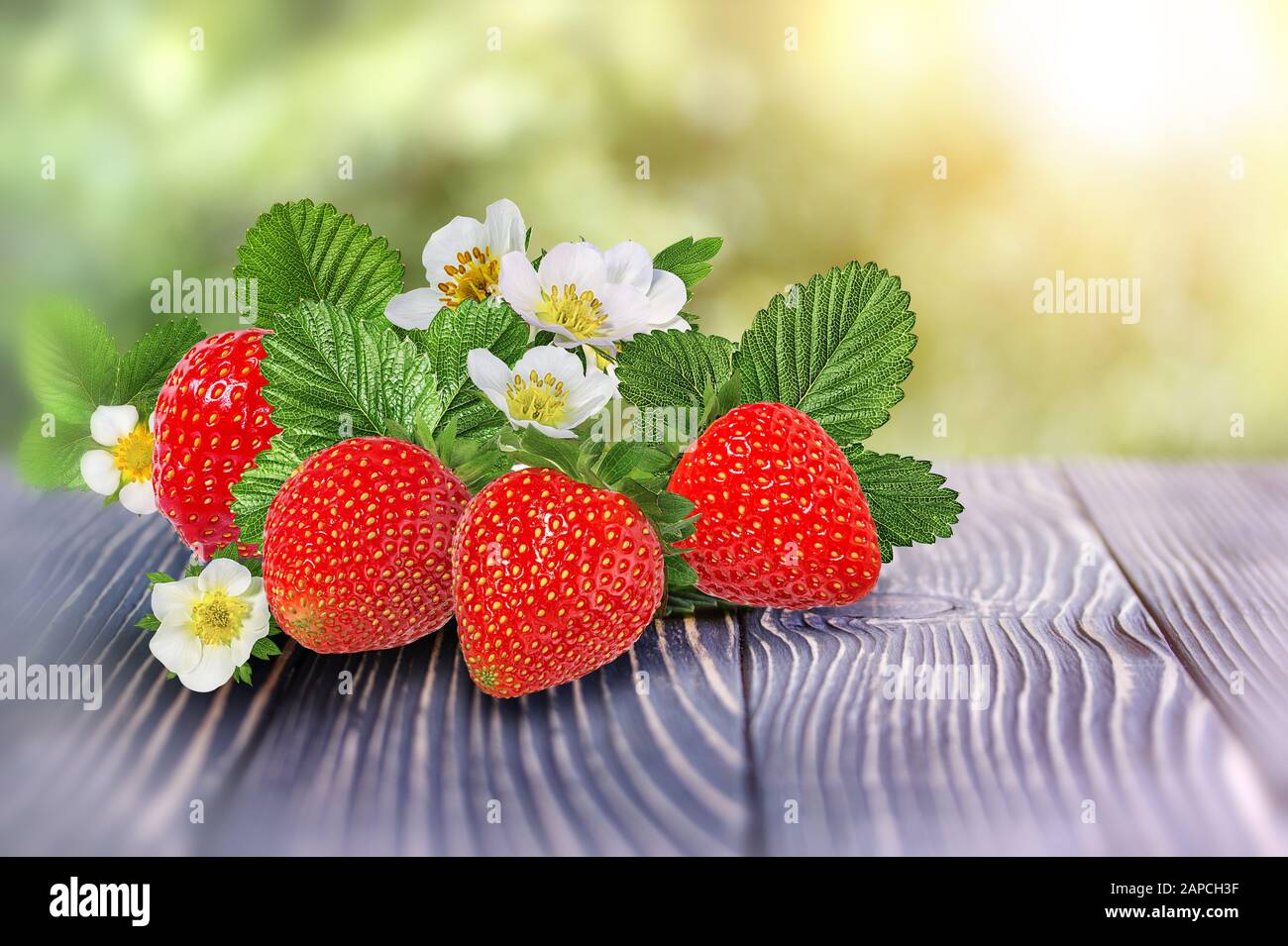 strawberries on a wooden old table outdoors Stock Photo - Alamy