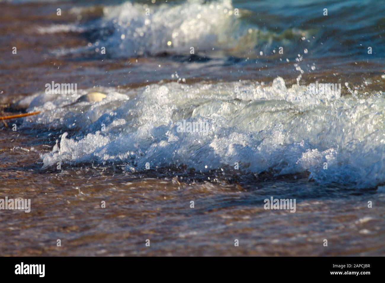 Sea waves with white foam on the seashore. Summer beach of the warm sea ...