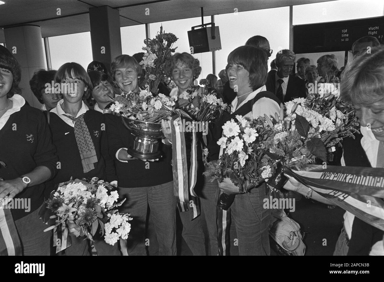 Arrival from Canada of world champion women's hockey Netherlands at Schiphol Description: Captain Maria Mattheussens with the cup Date: 31 August 1979 Location: Noord-Holland, Schiphol Keywords: arrival and departure, flowers, hockey, sports, trophies Personal name: Mattheussens-Fikkers, Maria Stock Photo