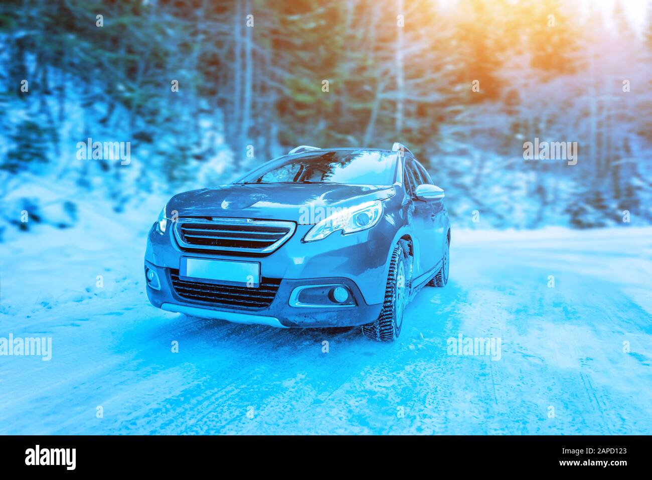 Driving the car on the icy road. View of the car from the front. Forest in the background Stock Photo
