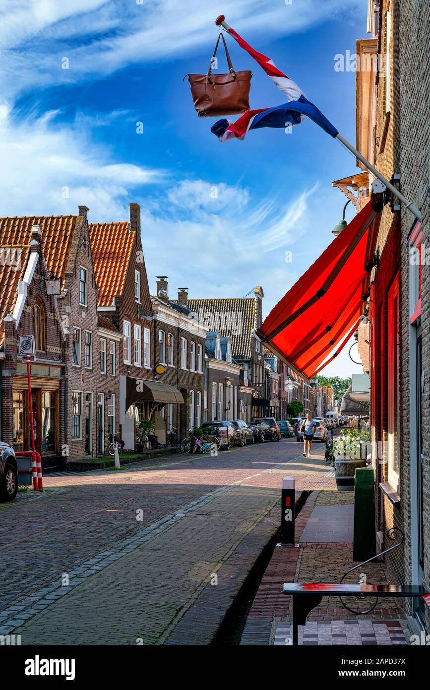 View of a narrow Street in Monnickendam near Amsterdam in the Netherlands. After passing the school leaving examination, a flag with the satchel is hu Stock Photo