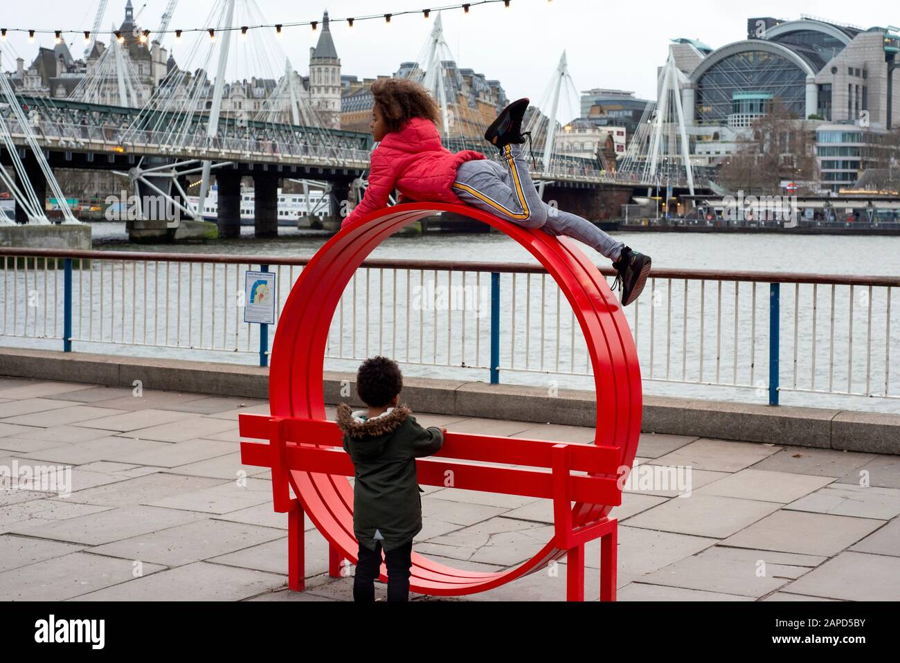 Black children playing and climbing a Jeppe Hein's Modified Social Benches on the South Bank Thames Path in London, UK, Europe as of 2020 Stock Photo