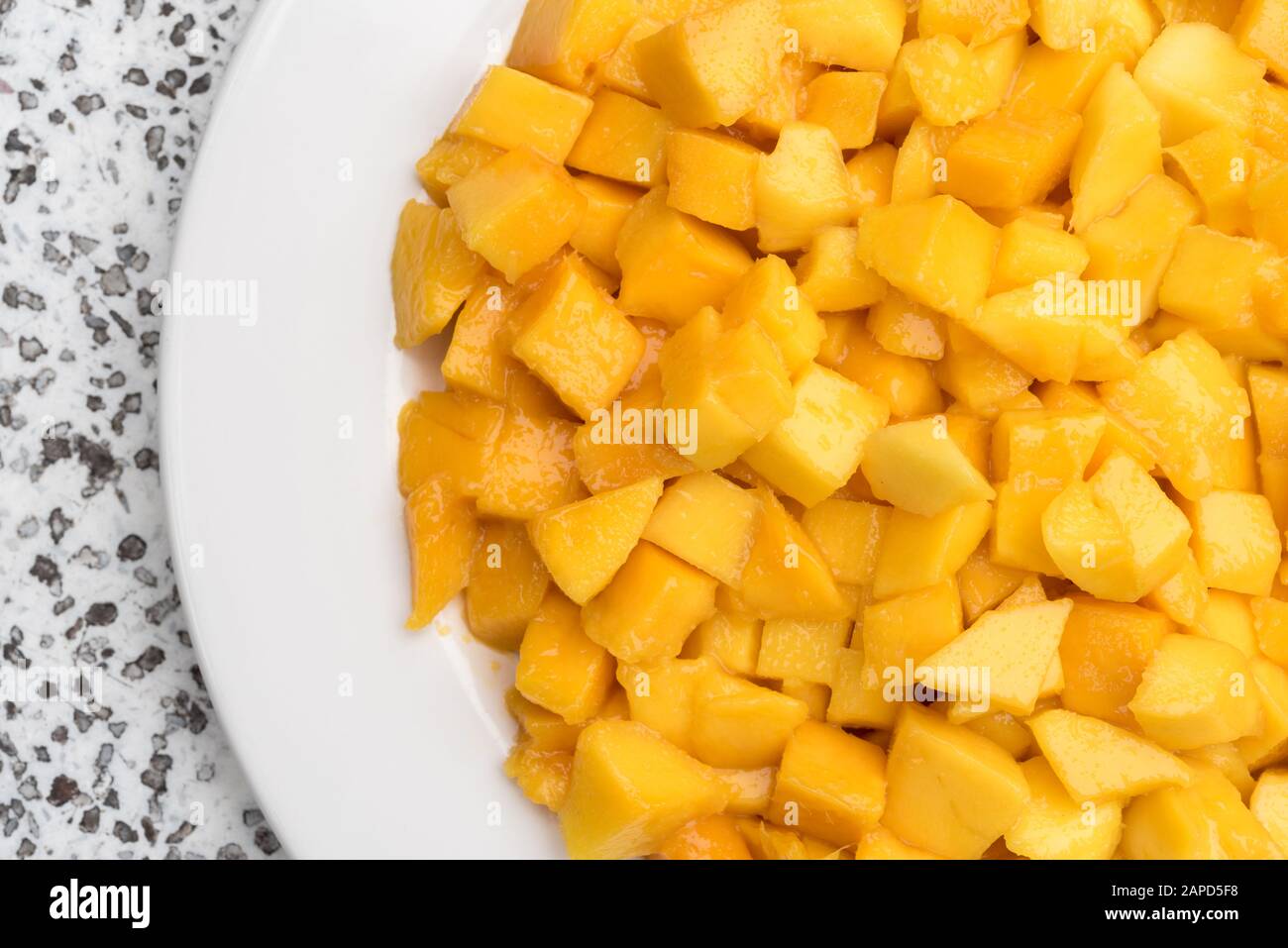 Mango chunks on plate. A close-up. Healthy natural food. Pieces of juicy yellow fruits. Stock Photo