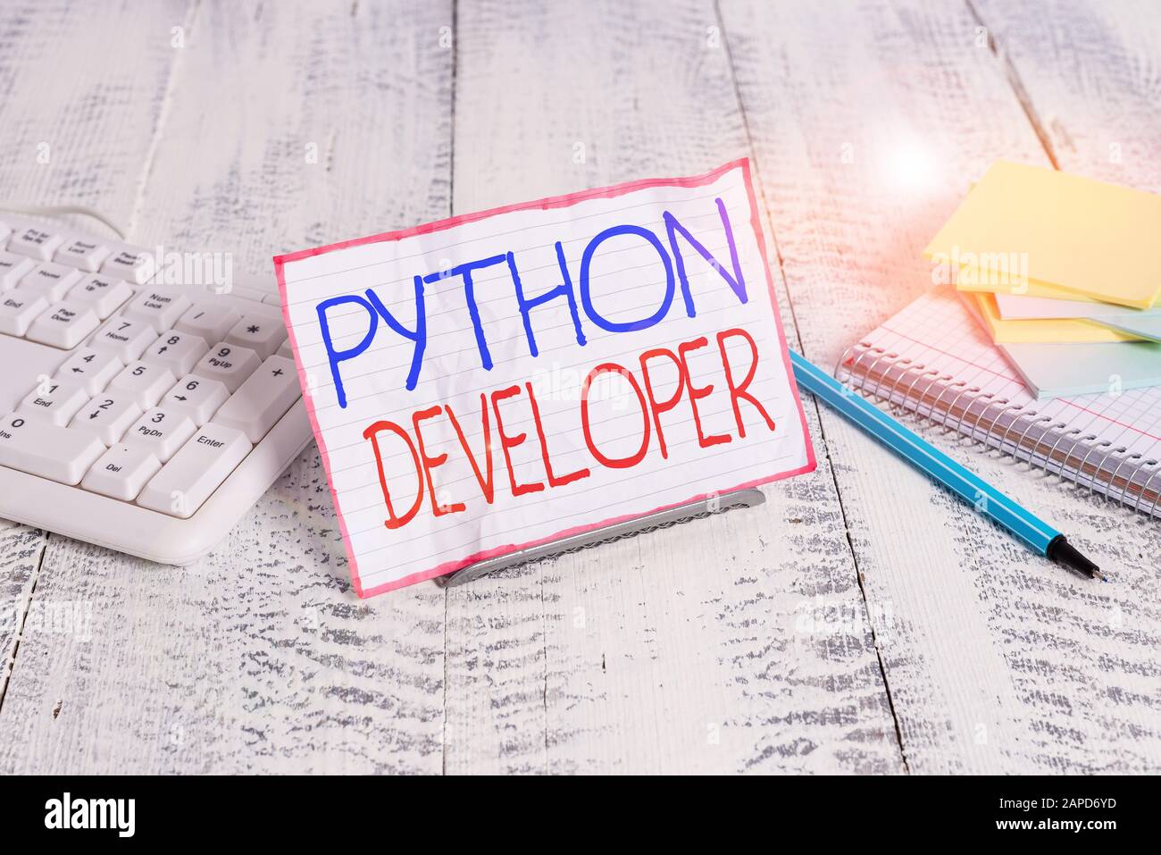 Writing note showing Python Developer. Business concept for responsible for writing serverside web application logic Notepaper on wire in between comp Stock Photo