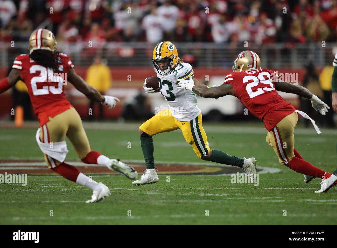 Green Bay Packers running back Aaron Jones (33) runs in front of San  Francisco 49ers cornerback Richard Sherman (25) and strong safety Jaquiski  Tartt (29) during the NFL football NFC Championship game,