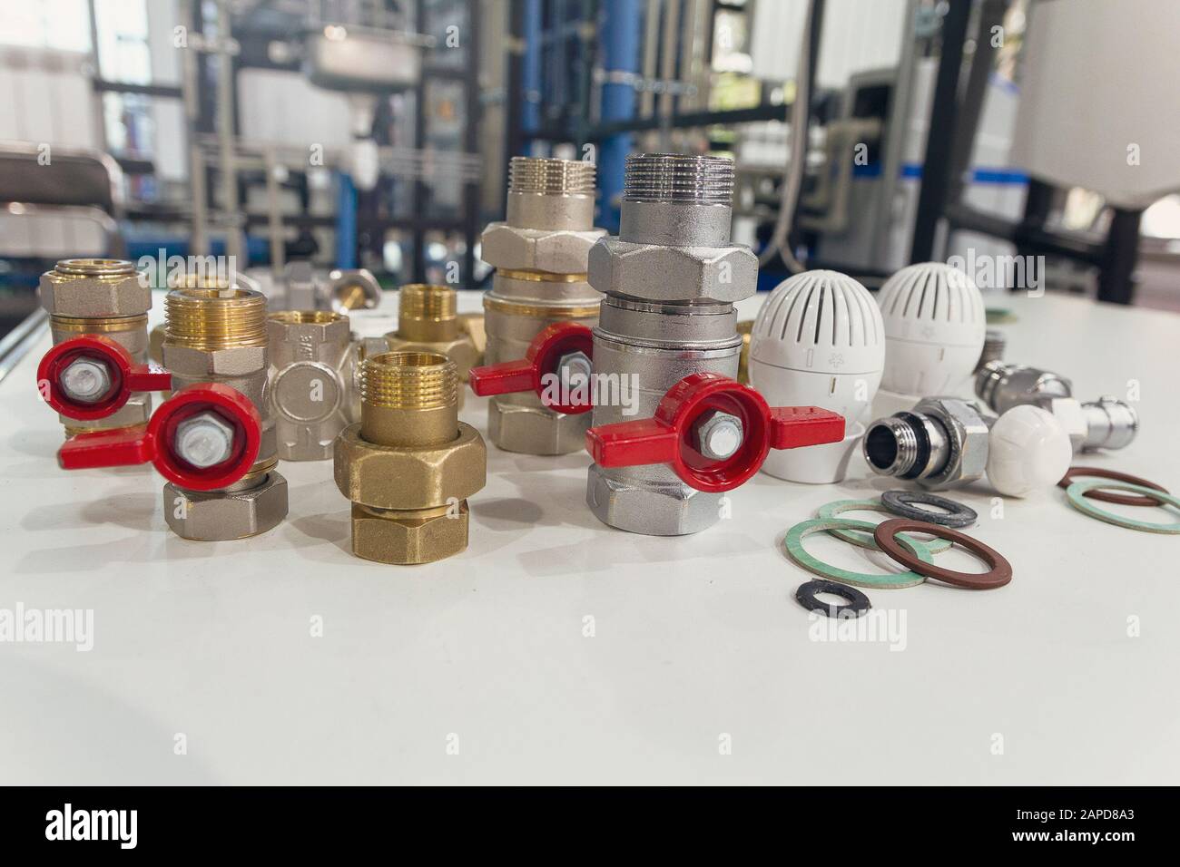 Water valves, fittings and thermostats on the table on the background of other heating equipment Stock Photo