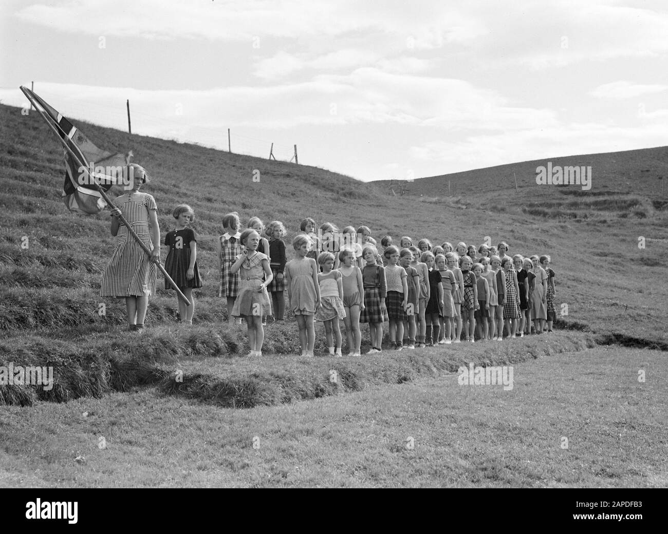 Iceland Description: Alafoss. Young girls, one of whom bearing the Icelandic flag, are lined up in line on the steps of an amphitheater Date: 1934 Location: Iceland, Àlafoss Keywords: amphitheatres, girls, ceremonies, flags Stock Photo