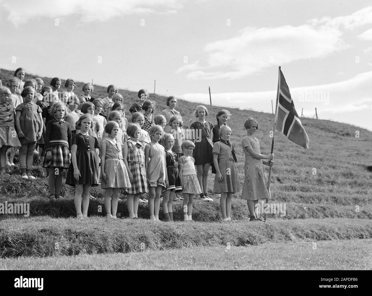 Iceland Description: Alafoss. Young girls, one of whom bearing the Icelandic flag, are lined up in line on the steps of an amphitheater Date: 1934 Location: Iceland, Àlafoss Keywords: amphitheatres, girls, ceremonies, flags Stock Photo