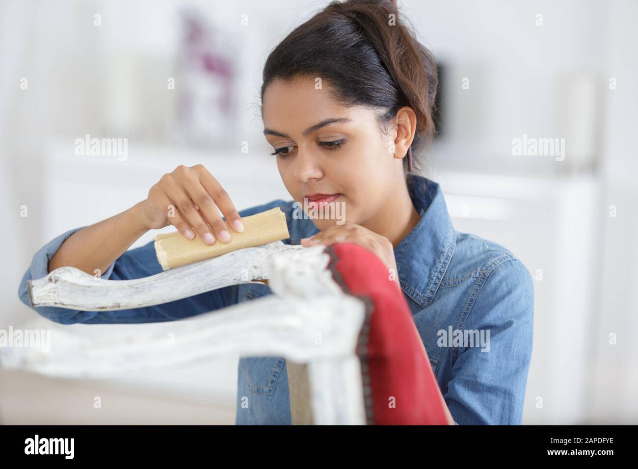 female furniture designer carefully sanding a chair Stock Photo Alamy