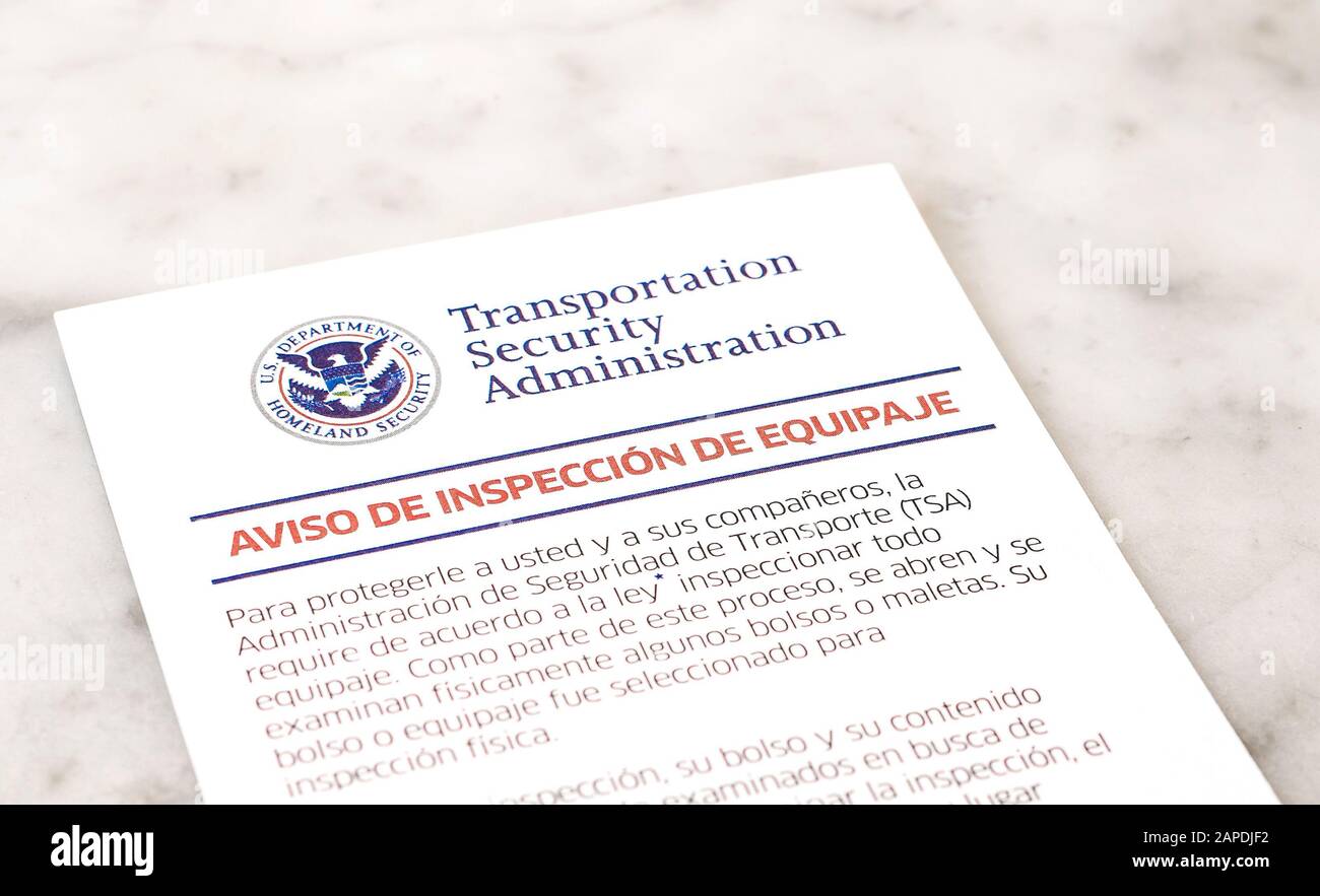 Notice of baggage inspection by TSA in Spanish. Shallow depth of field. Stock Photo