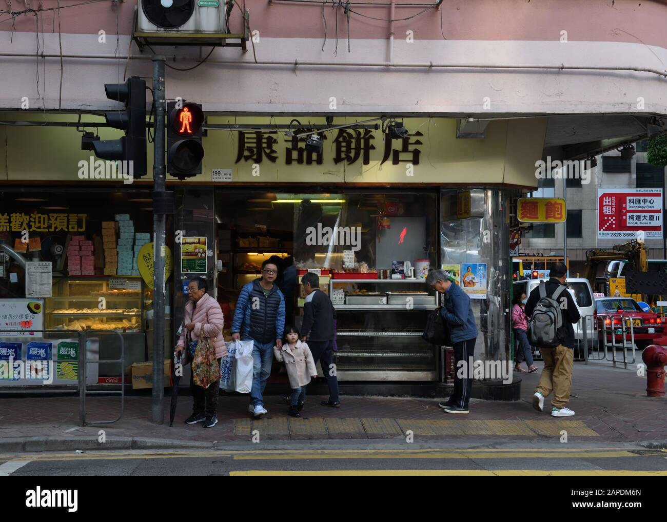 A corner shop selling hot fast food with Hong Kongers going about their