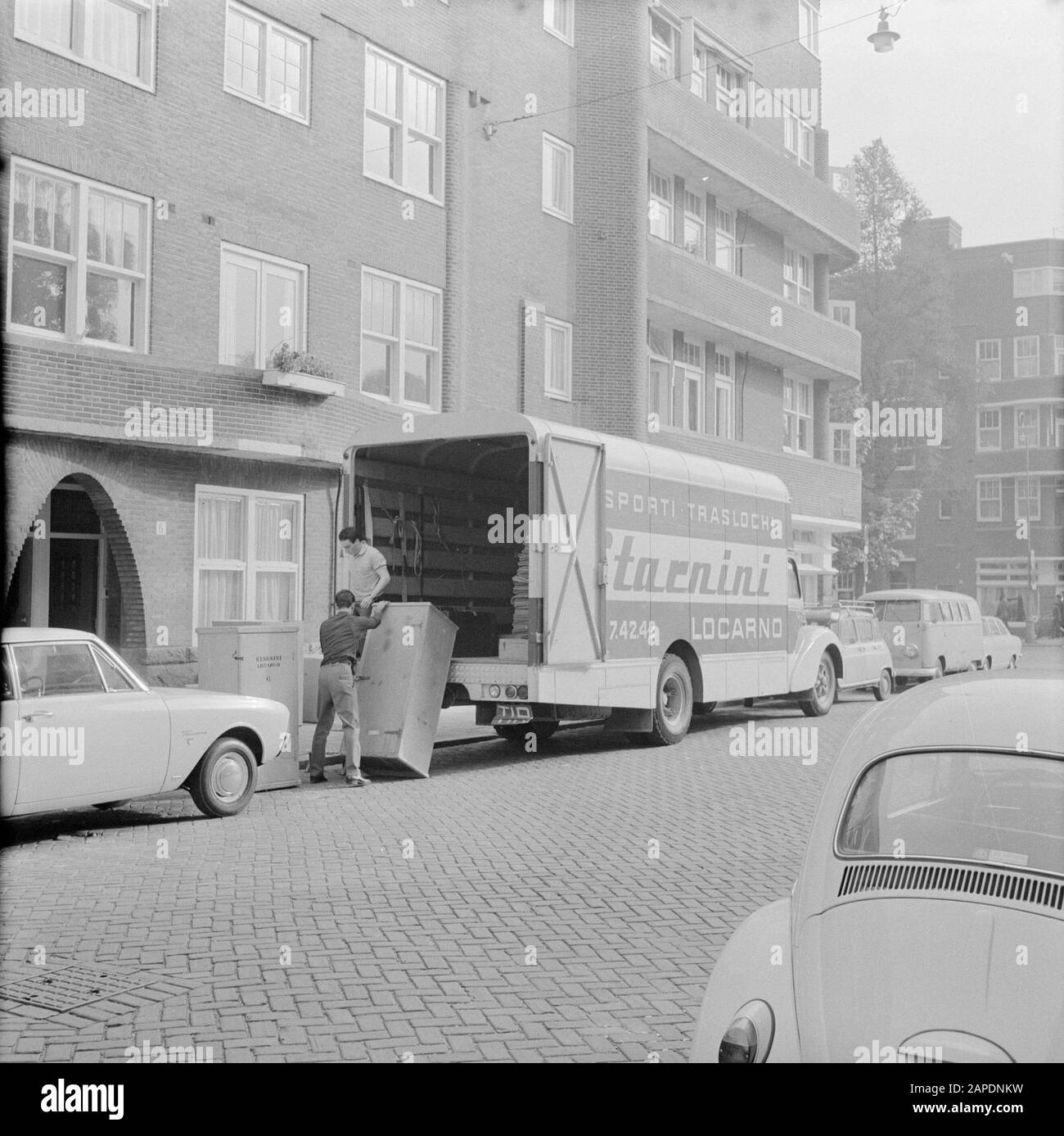 Living in Ascona Description: Amsterdam. De Van der Polls moving: two men loading or unloading a moving car from an Italian moving company from Locarno Date: 1 January 1967 Location: Amsterdam, Noord-Holland Keywords: street images, removals, trucks, homes Stock Photo