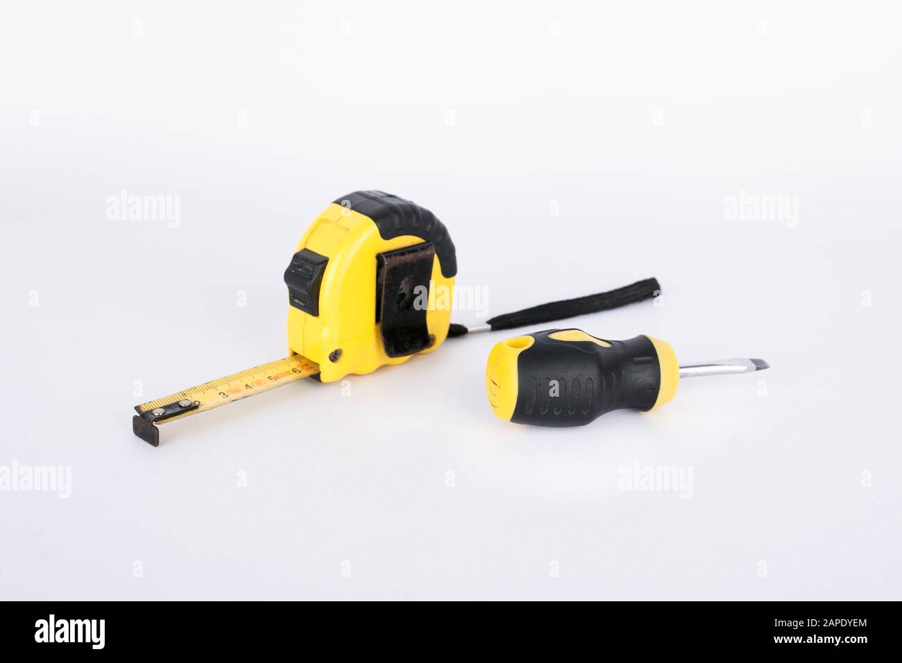 construction tape measure meter and screwdriver on a white background