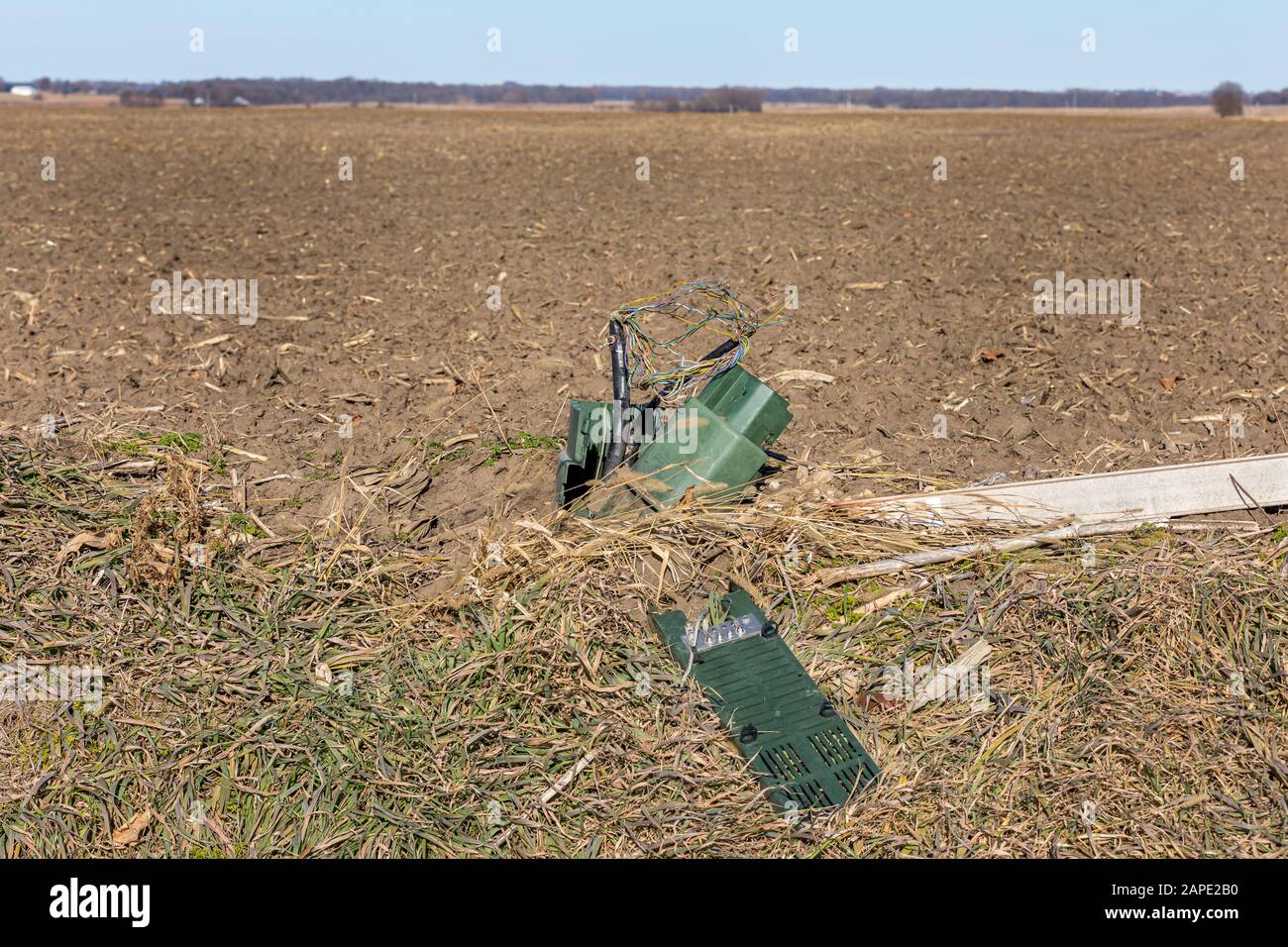 Telephone pedestal junction box damaged with exposed wires in ditch. Concept of rural telephone and internet access, repair, outage, and service Stock Photo