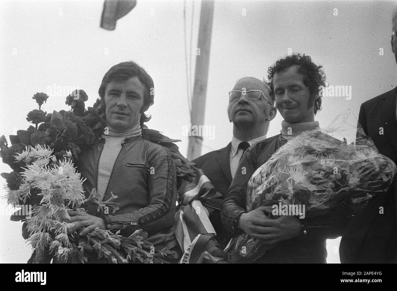 The award of the Spanish motorcycle driver Angel Nieto (l) and the Dutchman Jan de Vries who respectively placed first and second in the 50 cc class Español: Ángel Nieto y Jan de Vries en el podio de Assen (1972), categoría 50cc; Stock Photo