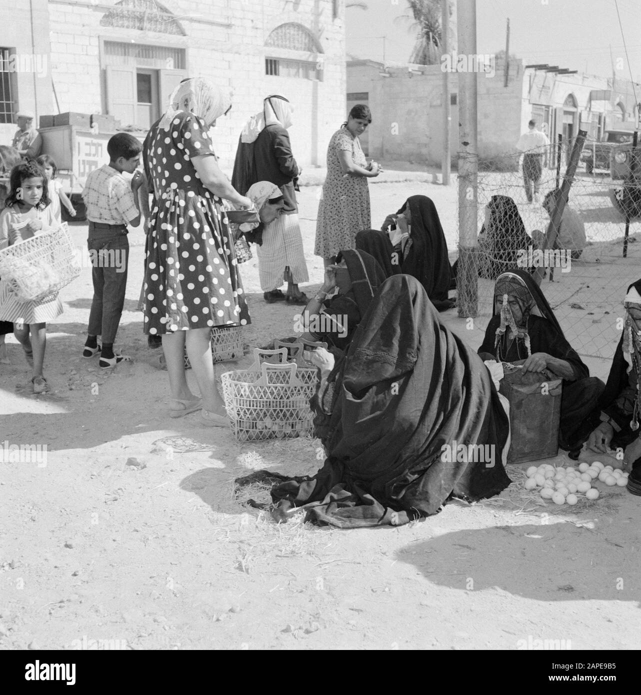 Israel 1960-1965: Bedouin in Beersewa (Beer Sheva) Description: Bedouin women in traditional costume on the market while offering eggs for sale. A customer pays her purchase Date: January 1, 1960 Location: Bersheba, Israel Keywords: Bedouin, Eggs, trade, markets, street images Stock Photo