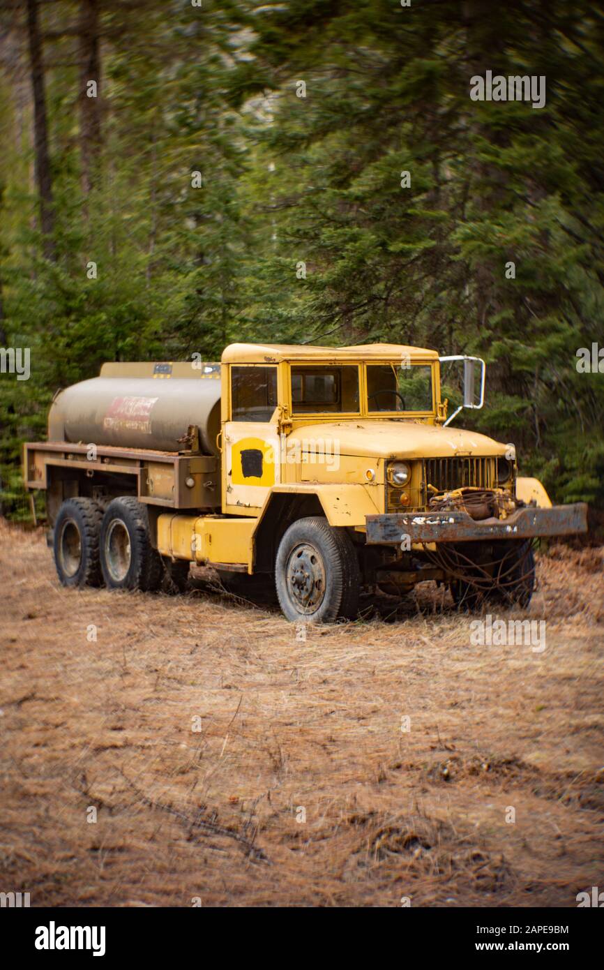 A US Military Korean War era REO M35 6x6 2 1/2 Ton 6x6 Water Tanker Truck, in a wooded area of Noxon, Montana. After the World War II ended, the US Go Stock Photo