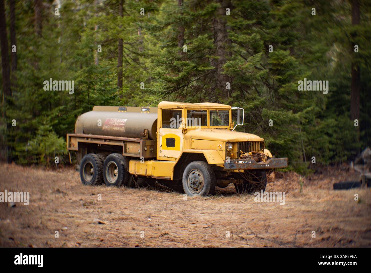A US Military Korean War era REO M35 6x6 2 1/2 Ton 6x6 Water Tanker Truck, in a wooded area of Noxon, Montana. After the World War II ended, the US Go Stock Photo